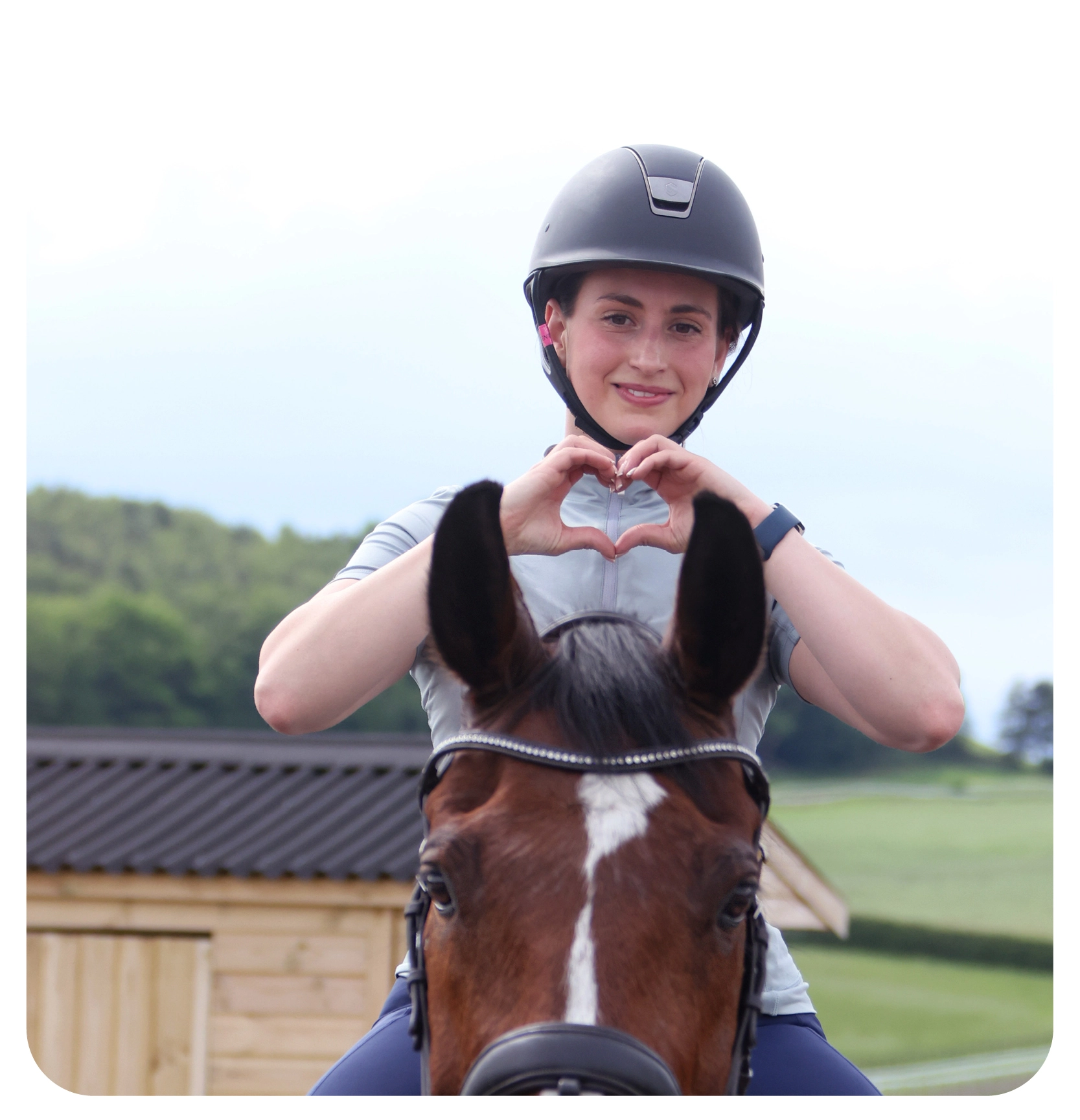 woman on a horse doing the heart sign 